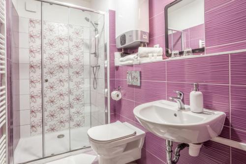 a bathroom with a sink and a toilet and a shower at Elendris - Ubytování u kostela in Brno