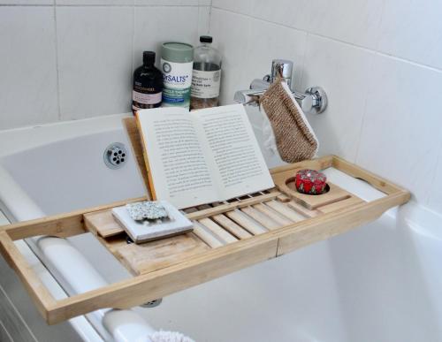 a book on a shelf in a bath tub at Cobbles Cottage, Honley in Honley