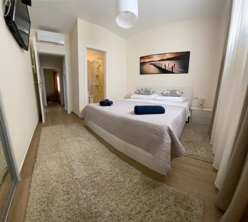 um quarto com uma grande cama branca com almofadas azuis em Villa Pergola -Apartment Roko em Mlini
