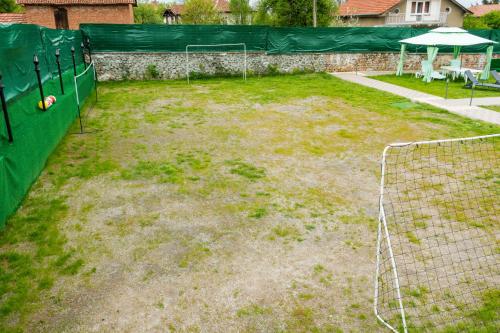 un campo da calcio con una rete in un cortile di Guest House Galabnik, Bulgaria a Gŭlŭbnik