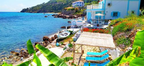 a view of a beach with blue buildings and the ocean at SEA SOUND Villa in Ágios Dimítrios