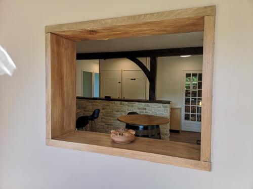 einen Spiegel an der Wand eines Zimmers mit einem Tisch in der Unterkunft Belle vue au cœur du Châtillonnais in Aisey-sur-Seine