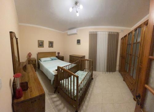 een slaapkamer met een bed en een wieg erin bij The Halcyon in Mellieħa