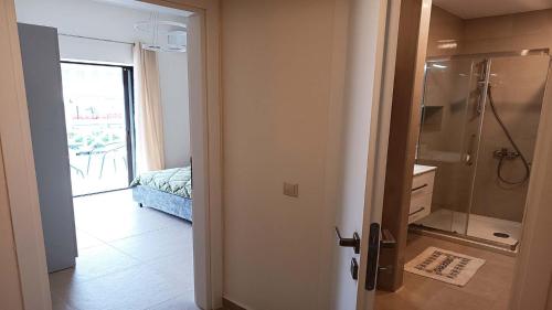 een badkamer met douche en glazen deur bij Hanioti Beach Front Apartments in Hanioti