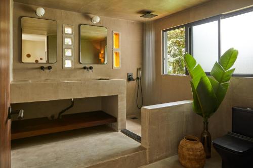 uma casa de banho com um lavatório e um espelho em SELVA by DW em Fajardo