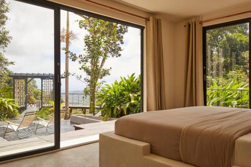 a bedroom with a bed and a large window at SELVA by DW in Fajardo