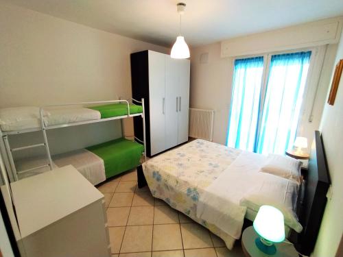 Cette petite chambre comprend un lit et des lits superposés. dans l'établissement Case vacanza Erica Igea Marina, à Bellaria-Igea Marina