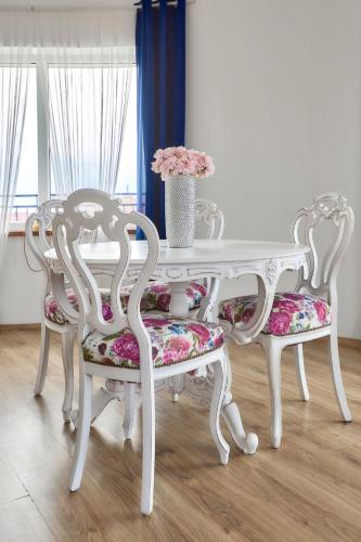 a white table and two chairs with a table and flowers at Krab in Rewal