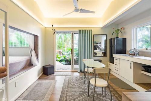 a kitchen with a table and chairs and a bed at PonoMana Oasis's - Koi Cottage in Captain Cook