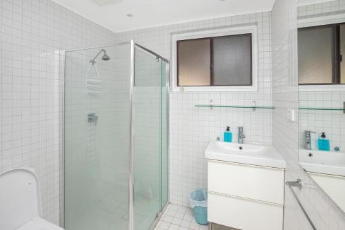 a bathroom with a glass shower and a sink at Wallis View 3 in Forster