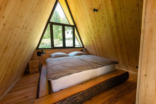 a bedroom with a bed in a room with a window at Baumhausapartment in Breuberg
