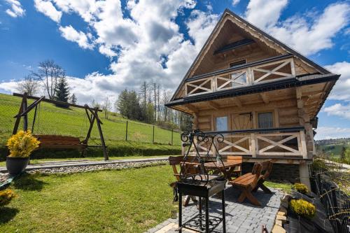 a log cabin with a table and chairs and a bench at DOMKI NA WIERCHU in Biały Dunajec