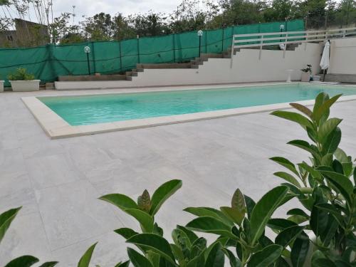 a swimming pool with blue water in a building at Casa Vacanze Villa Tropia in Camastra ex Solfara