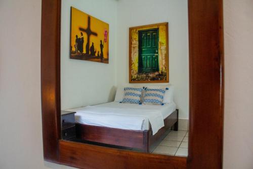 a mirror reflecting a bed in a room at Los Amigos Hostel in Flores