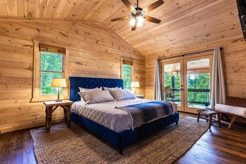 a bedroom with a blue bed and wooden walls at Luxe Family Cabin 8 min to Downtown Blue Ridge in Blue Ridge