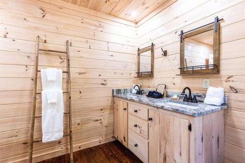a bathroom with a sink and a wooden wall at Luxe Family Cabin 8 min to Downtown Blue Ridge in Blue Ridge