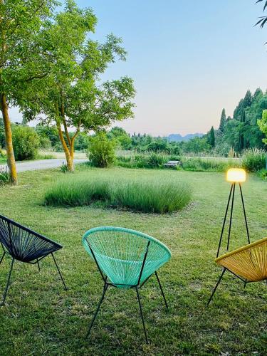 two chairs and a table in the grass at Le Mas d’Aloha in Plan-dʼOrgon