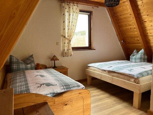 1 Schlafzimmer mit 2 Betten in einem Blockhaus in der Unterkunft Flügels ReBi-Baude in Rechenberg-Bienenmühle