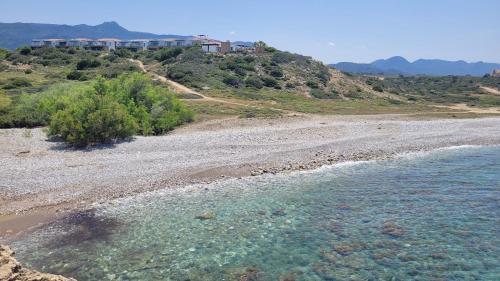 a view of a beach with rocks and water at Sea and Mountain View Beachfront Penthouse in Yalı