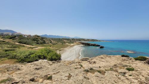 a view of a beach on a hill with the ocean at Sea and Mountain View Beachfront Penthouse in Yalı