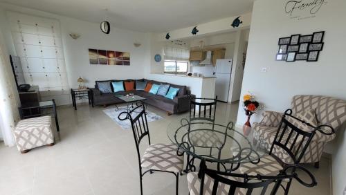 a living room with a couch and a table and chairs at Sea and Mountain View Beachfront Penthouse in Yalı