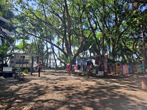 a group of people standing around a market under a tree at Casa Uvita Bay in Uvita