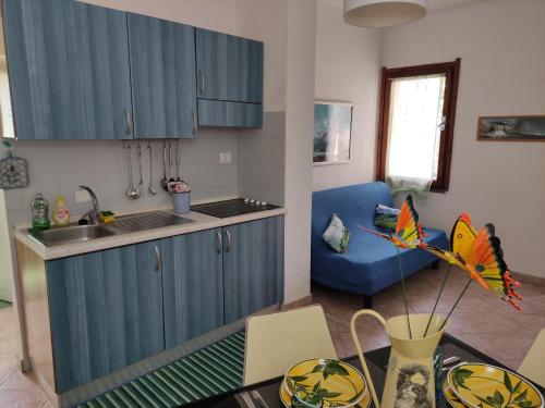 una cucina con armadi blu e un tavolo con aquilone di San Teodoro a San Teodoro