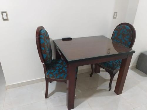une table en bois avec deux chaises et une table dans l'établissement Aswan Hotel Appartments, à Assouan