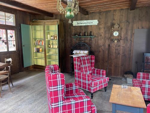 a living room with red chairs and a table at Berghotel Gasterntal in Kandersteg