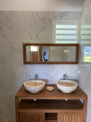 two sinks on a wooden counter in a bathroom at Le Chalet des Rêves Ensoleillés in Saint-François