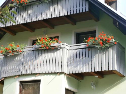 a house with two balconies with flowers on it at Apartment Žvan in Bohinj