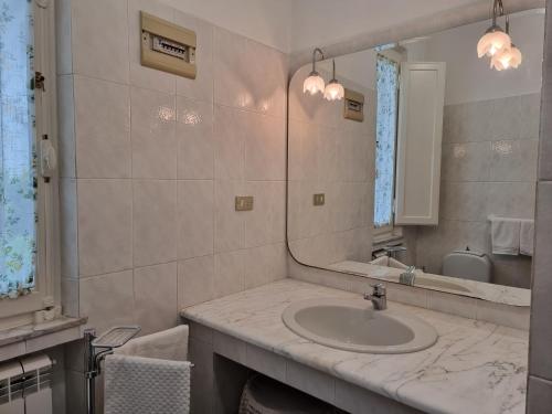 uma casa de banho com um lavatório e um espelho em La Casa di Marta 