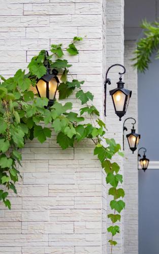 two lights attached to a brick wall with ivy at Vila Pugliesi Hotel Boutique in Lençóis