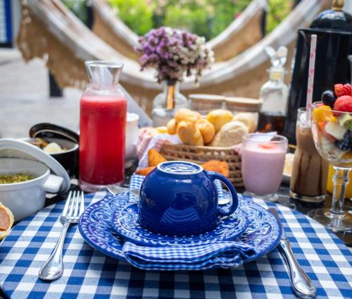 a table with a blue teapot on a blue and white table cloth at Vila Pugliesi Hotel Boutique in Lençóis