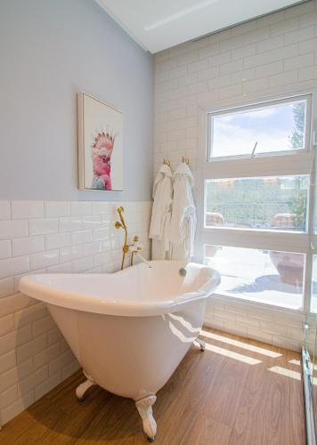 a white bath tub in a bathroom with a window at Vila Pugliesi Hotel Boutique in Lençóis