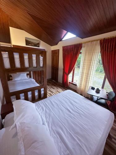 a bedroom with two beds and a window at Brisas del Río in Mindo