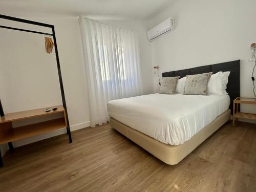 a bedroom with a white bed and a wooden floor at Casas da Praia by Aqualeisure in Furadouro