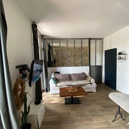 ein Wohnzimmer mit einem Sofa und einem Tisch in der Unterkunft Jolie appartement en plein centre du village in Les Arcs sur Argens