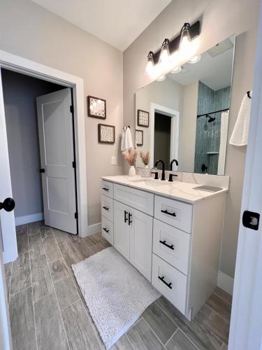 a bathroom with a sink and a large mirror at Swanky Seahorse in Carolina Beach