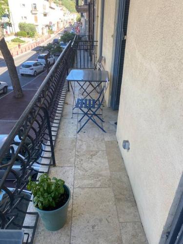 einen Balkon mit einem Tisch, Stühlen und einer Straße in der Unterkunft Jolie appartement en plein centre du village in Les Arcs sur Argens
