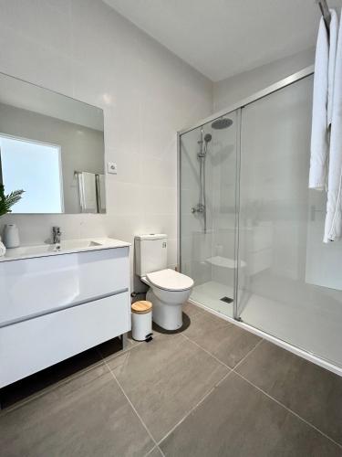 a white bathroom with a toilet and a shower at Casas da Praia by Aqualeisure in Furadouro