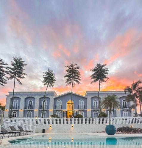 a building with a pool in front of a sunset at Vila Pugliesi Hotel Boutique in Lençóis