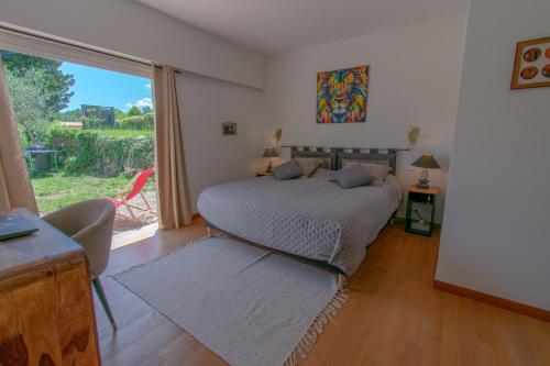 a bedroom with a bed and a large window at Villa Aixela 220m2 - 4ch - Piscine & Jardin 3000m2 in Fayence