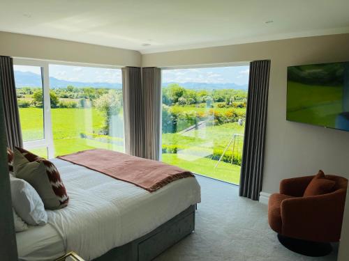 a bedroom with a bed and a large window at Country View House in Milltown