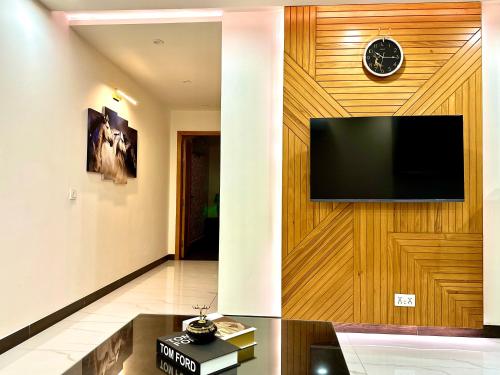 a living room with a tv on a wooden wall at Lux Haven Apartments in Lahore near Gulberg - Exclusive Spaces for Exceptional Stays in Lahore