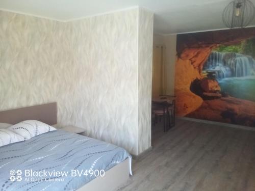 a bedroom with a painting on the wall next to a bed at Aquadetente loudeac in Loudéac