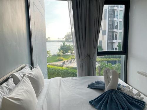 une femme dormant sur un lit devant une fenêtre dans l'établissement Best location in Laguna-modern apartment at Cassia, à Bang Tao Beach