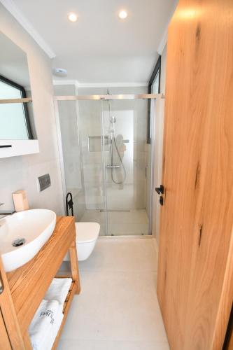 a bathroom with a shower and a sink and a toilet at Blue Point Hotel Yalikavak in Yalıkavak