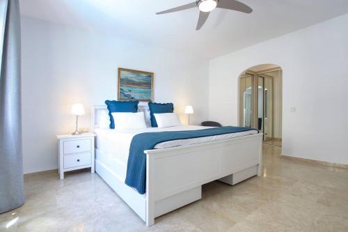 a white bedroom with a bed and a ceiling fan at Marina Bay by Asola Property in Estepona