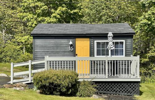 a black and yellow shed with a white fence at Seascape Motel & Cottages in Belfast